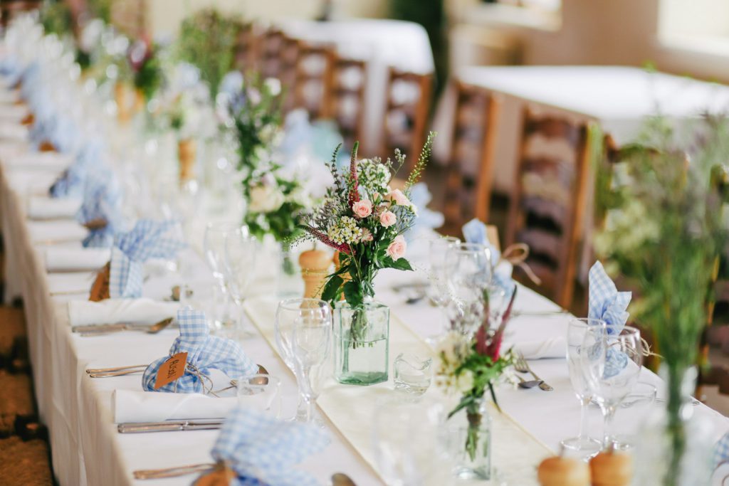 A long banquet table dressed for a summer wedding